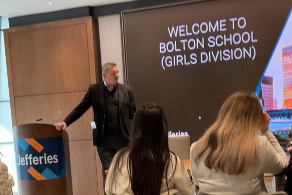 A group of participants attending a Junior Trader finance and investing workshop, captured during an informal networking session in a corporate learning space.